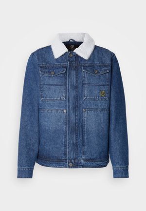 Tamsiai mėlyna džinsinė striukė su balta dirbtine avikailio apykakle. Turinti dvi krūtinės kišenes, mygtukų užsegimą ir šiek tiek prigludusią formą.