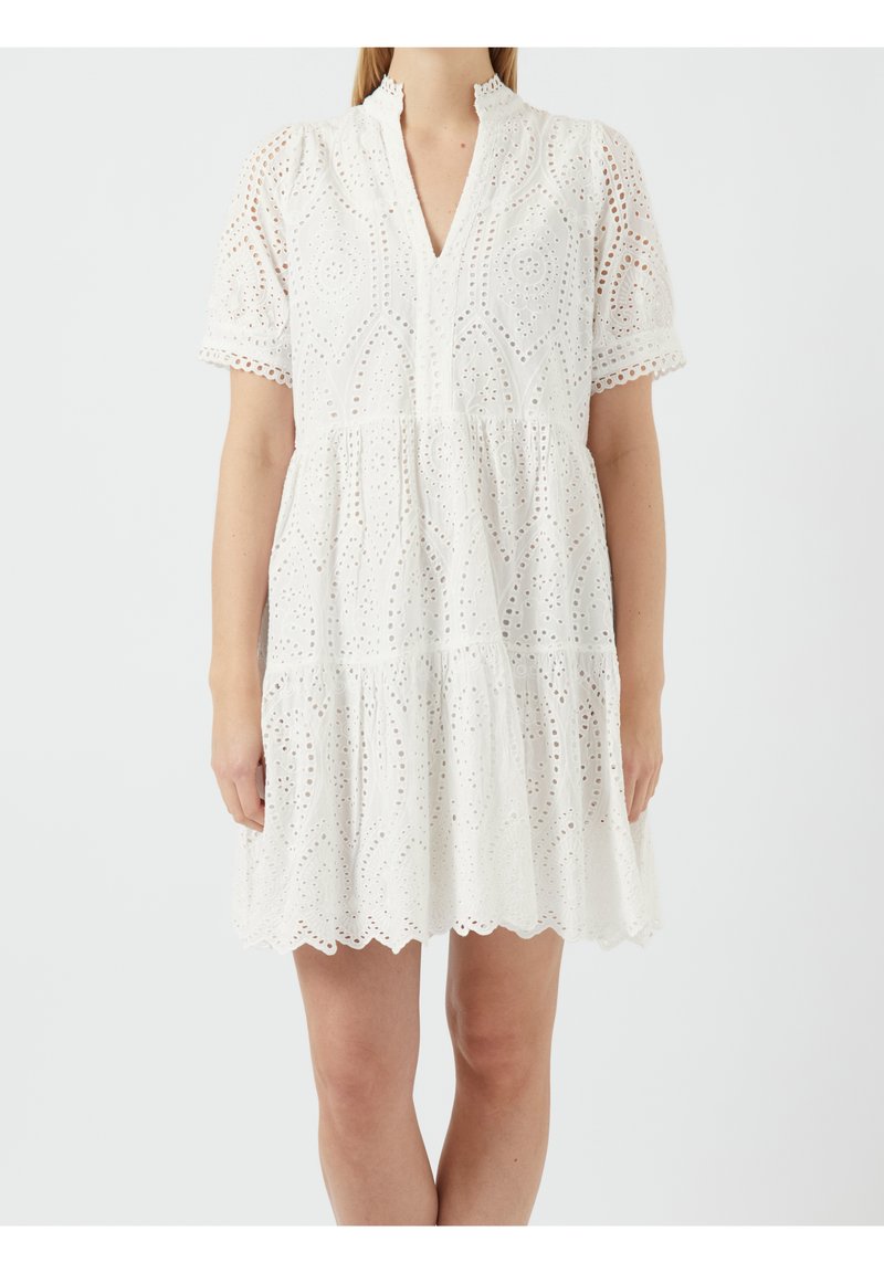 Vit bomullsklänning med hålbroderi, lagerdesign, korta ärmar, scalloped nederkant och en halsringning med en partiell knappslå.