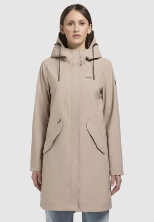 Beige waterdichte jas met een capuchon, voorrits en zijzakken. Kenmerkt zich door een soepele textuur en een minimalistisch ontwerp met subtiele stiknaden.