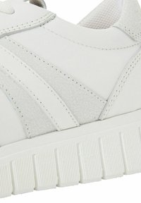 Baskets blanches en cuir texturé avec des accents lisses, dotées d'une semelle en caoutchouc épaisse et rainurée, ainsi que de coutures pour un meilleur soutien.
