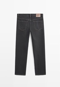 Jean en denim noir avec une coupe droite, comportant deux poches arrière et une étiquette en cuir brun à la taille. Ourlet fini avec des surpiqûres contrastées.