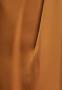 Satin stof in een warme, rijke bruine kleur met een gladde textuur en subtiele glans, met zachte draperingen en lichte vouwen.