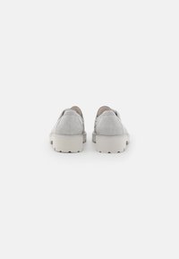 Graue Wildlederschuhe mit runder Zehenform und elastischen Seiteneinsätzen. Dicke weiße Gummisohle mit strukturiertem Profil. Die Rückansicht zeigt minimalen Nähten.