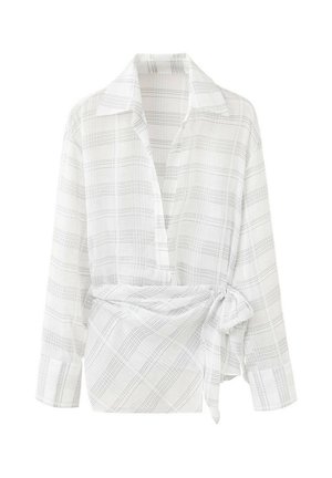 Blouse blanche à manches longues portefeuille avec fines lignes à carreaux gris et un lien latéral à la taille, avec un col classique et des poignets boutonnés.