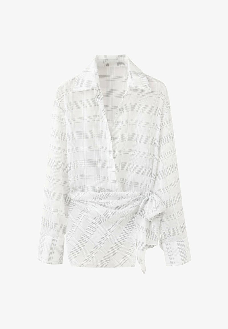 Blouse blanche à manches longues portefeuille avec fines lignes à carreaux gris et un lien latéral à la taille, avec un col classique et des poignets boutonnés.