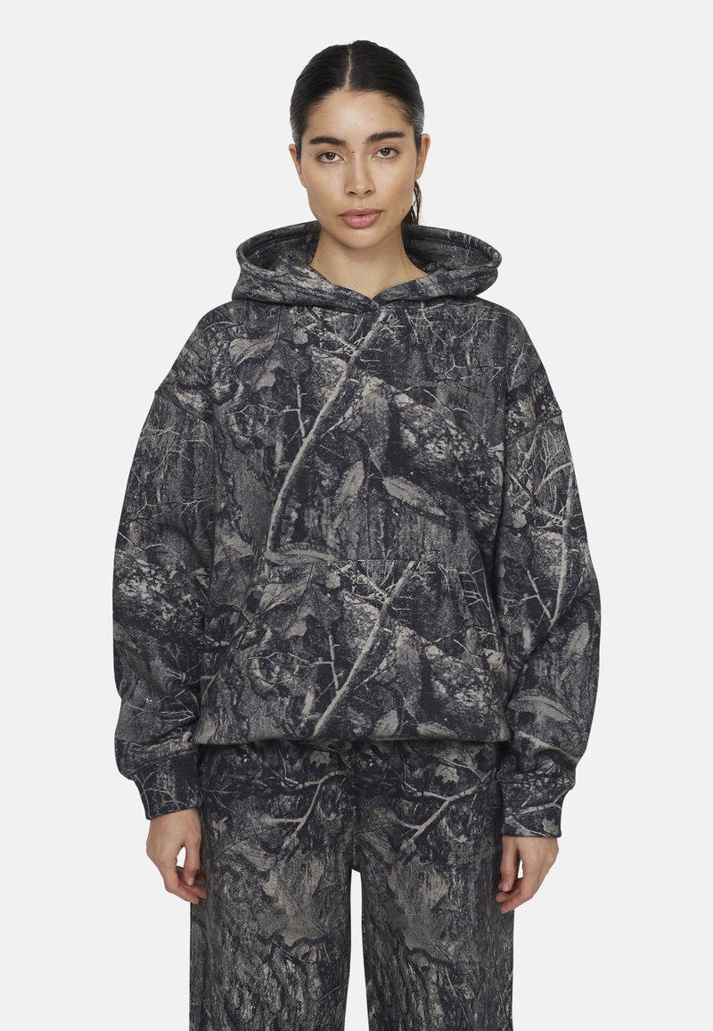 Pullover felpa con cappuccio di colore grigio scuro con stampa camouflage caratterizzata da foglie e rami. Tessuto morbido con cappuccio e tasca a canguro.