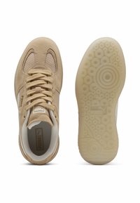 Tan suede sneakers with mesh accents, round laces, and a textured beige rubber sole featuring circular patterns. Puma logo on the tongue.