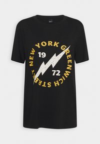 Černé tričko s krátkými rukávy, na kterém je bílé bleskové logo a žlutý text v kruhu: "NEW YORK GREENWICH 1972". Měkká bavlněná tkanina.