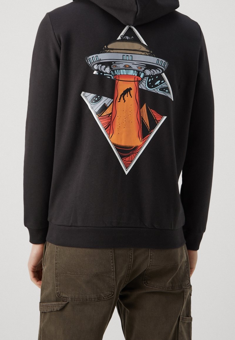 Felpa nera con cappuccio, caratterizzata da una grafica colorata di un rapimento alieno sul retro, con un motivo a diamante e elementi arancioni a contrasto.