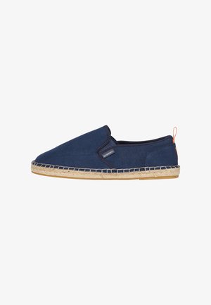 Mørkeblå canvas slip-on sko med en sål af jute reb, med en syet kant og et lille logo-mærke på siden. Diskret orange accent på hælen.