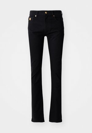 Mustad teksased, slim fit lõikega, valmistatud denimist. Omab esist nupuga kinnitamist, kahte esikotti ja dekoratiivseid detaile vöökohtadel.