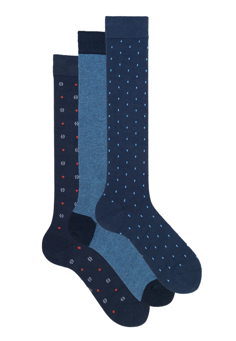 Tre paia di calzini al ginocchio: uno blu scuro con motivi rossi e bianchi, uno azzurro uniforme e uno blu scuro con pois azzurri.