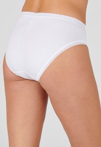 Witte katoenen slip met een hoge taille, voorzien van een decoratieve kantafwerking langs de tailleband. Gladde textuur, minimalistisch ontwerp en volledige bedekking.
