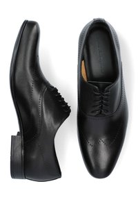 Czarne skórzane buty do garnituru o gładkim wykończeniu, spiczastym nosku, dekoracyjnym zdobieniu brogue oraz niskim, złożonym obcasie. Zapięcie na sznurowadła.
