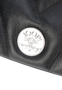 Borsa a mano in pelle nera con logo circolare in argento JOOP! Jeans, caratterizzata da dettagli decorativi e una superficie testurizzata.