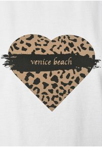 Herzförmige Grafik mit einem sandfarbenen Leopardenmuster auf weißem Hintergrund, mit dem Text "Venice Beach" in einem schwarzen Pinselstrich-Akzent.