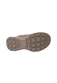 La suola della scarpa presenta un design in gomma testurizzato beige, con motivi rettangolari e circolari per una maggiore aderenza, e una leggera curvatura ai bordi.