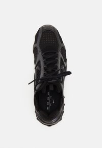 Baskets Nike Air 2000 noires et grises avec panneaux en mesh et lacets, vues de dessus sur un fond blanc.