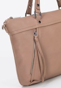 Sac à main en cuir beige avec une poche zippée verticale, un tirant en cuir assorti et des poignées doubles avec des accents de bouton en métal.