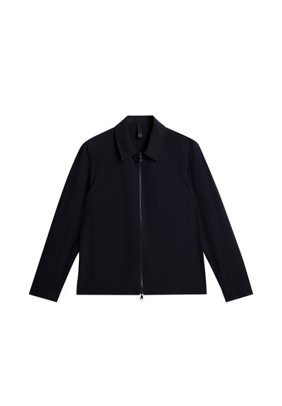 Giacca zip-up navy con colletto a punta, maniche lunghe, tasca frontale e texture liscia. Design semplice, senza motivi o accenti visibili.
