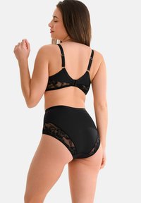 Soutien-gorge en dentelle noire avec des bretelles réglables et une fermeture à crochet. Culottes taille haute. Tissu lisse avec des accents de dentelle florale.