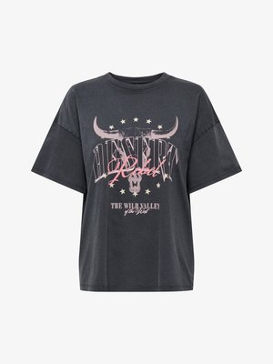 T-shirt oversize gris foncé avec les inscriptions « Desert Rebel » et « The Wild Valley of the West », avec un graphique représentant un crâne de taureau et des étoiles sur le devant.