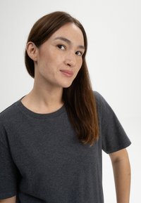 Charcoal grijze t-shirt gemaakt van zachte stof, met een ronde halslijn en korte mouwen, een subtiele textuur en een relaxed fit.