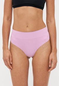 High-waisted underwear in light pink fabric, featuring a seamless design and smooth, stretchable texture for comfort and fit.