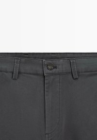 Szare bawełniane spodnie z zapięciem na guzik, szlufkami na pasek i ukośnymi przednimi kieszeniami z subtelnymi detalami szwów. Gładka tekstura.