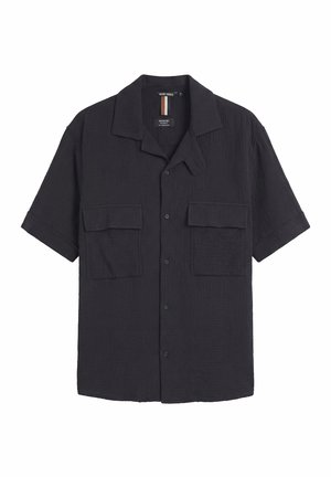 Camisa negra de manga corta con botones, dos bolsillos frontales con solapa y cuello con muesca, presentada sobre un fondo blanco liso.