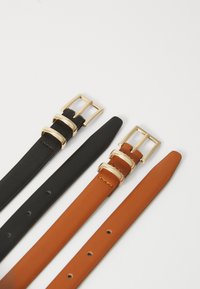 Dos cinturones: uno negro y uno marrón, ambos con hebillas de metal dorado. Los cinturones tienen una textura suave y varios agujeros de ajuste.