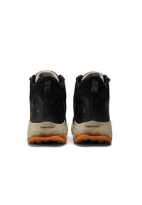Black hiking shoes with a mesh and synthetic upper, featuring a tan Fresh Foam midsole and orange outsole, designed for traction and comfort.
