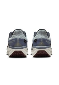 Chaussures de course GORE-TEX avec un dessus bleu et gris, texture matelassée, dos sombre et une semelle texturée blanche et bordeaux pour une meilleure traction.