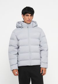 Light gray puffer jacket with a zipper and adjustable hood. Features quilted sections and a simple logo on the chest. Smooth texture.