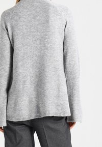 Szary sweter dziany o luźnym kroju, z prążkowanym obrzeżem i rękawami raglanowymi, charakteryzujący się miękką teksturą i szerokim dekoltem.