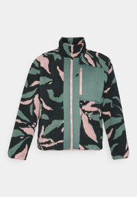 Giacca zip-up in peluche con motivo astratto verde, nero e rosa, tasca sul petto in tessuto verde e dettagli della cerniera rosa.