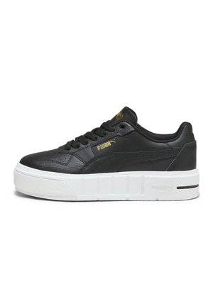 Czarny niski sneaker Puma z złotymi detalami logo i grubą białą teksturowaną podeszwą, pokazany z boku na białym tle.