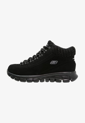Czarny zamszowy sneaker typu high-top z teksturowanym dzianinowym kołnierzem, metalowymi oczkami i elastyczną gumową podeszwą zapewniającą przyczepność i wsparcie.
