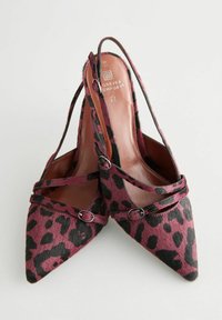 Leopard-print pointy-toed pumps in dark pink and black, featuring a soft texture, crossed straps, and metal accent buckles.