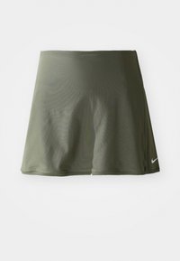 Olive zaļš sporta svārki, izgatavoti no gludas, elastīgas auduma, ar platu vidukļa gumiju un mazu Nike logotipu apakšējā labajā stūrī.