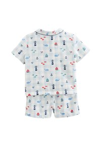 Ensemble de pyjama en coton avec un fond bleu clair et un thème nautique. Les motifs incluent des baleines, des phares, des voiliers et des poissons.