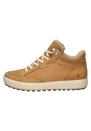 Botte en daim marron à la cheville avec doublure beige, semelle en caoutchouc et lacets crème. Dispose d'une étiquette Gore-Tex imperméable et de détails texturés sur la tige.