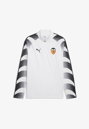 Haut de sport blanc à manches longues avec des rayures dégradées noires sur les manches, col à demi-fermeture éclair, logo Puma et écusson du club de football Valencia CF sur le devant.