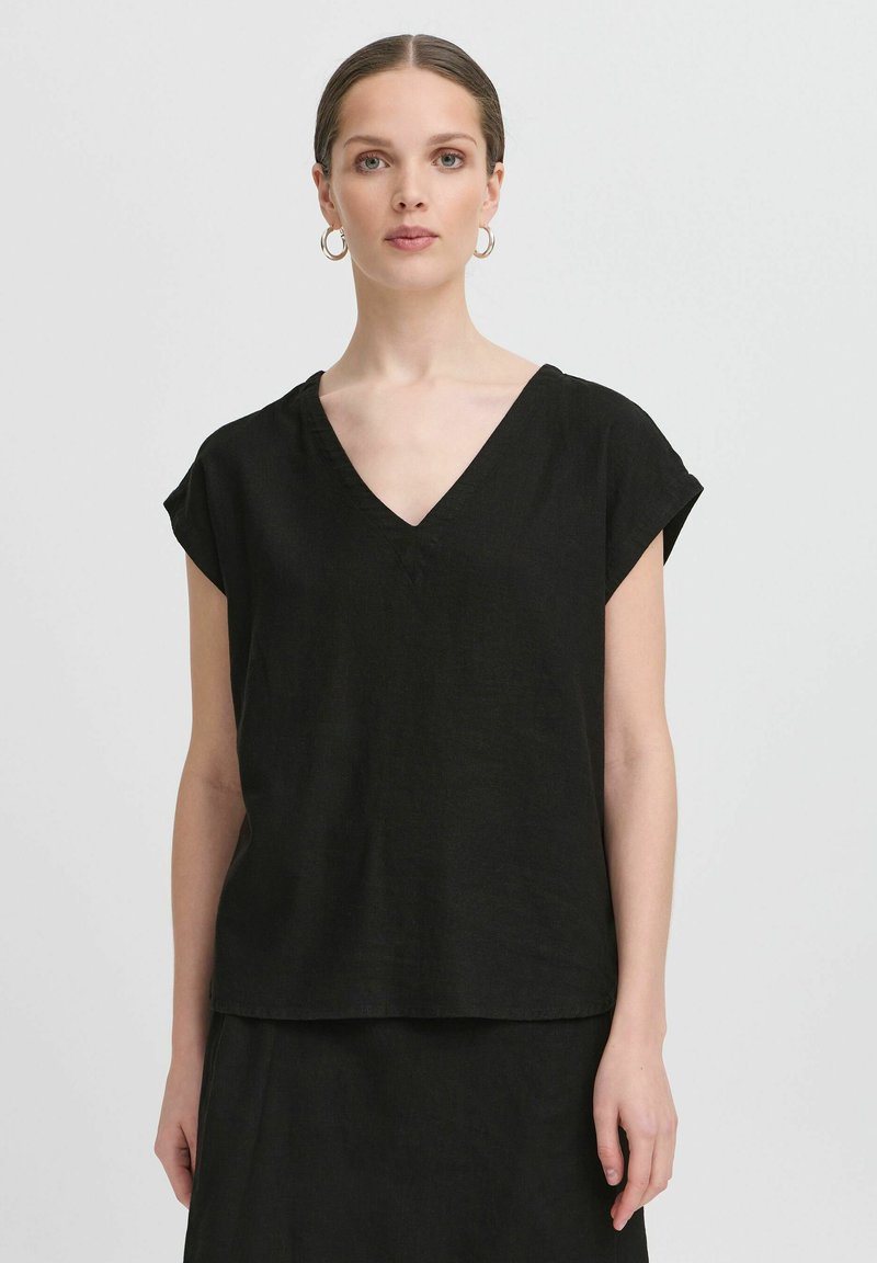 Top corto in lino nero con scollatura a V profonda, vestibilità ampia e design rilassato. Texture liscia e dettagli di cucitura minimi.