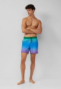 Zwemshort in verloopkleuren van blauw, groen en paars. Voorzien van een elastische tailleband met koord, zijzakken en een zachte textuur.