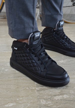 Sneaker alte nere in pelle texturizzata con pannelli laterali trapuntati e puntale liscio, dotate di lacci neri e linguetta sul tallone con marchio.