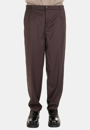 Pantaloni marroni, morbidi e comodi, con una texture liscia, chiusura con un solo bottone e passanti per la cintura, abbinati a scarpe nere.