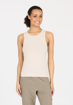 Beige mouwloze tanktop gemaakt van zachte stof, met een ronde halslijn en een aansluitend ontwerp. Draagt bij lichte grijze broek.
