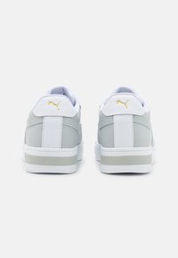 Sneakers Puma w szaro-białym wzorze, z gładką skórzaną teksturą, złotymi akcentami i białą gumową podeszwą.