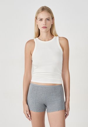 Canottiera bianca a coste con scollo rotondo e pantaloncini grigi con texture. La canottiera è aderente, mentre i pantaloncini arrivano a metà coscia e sono senza cuciture.